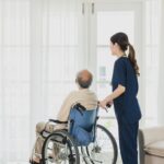 Senior man in wheelchair receives medical help for injury