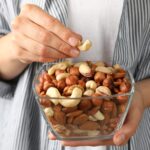 Woman hold bowl with different nuts. Healthy eating